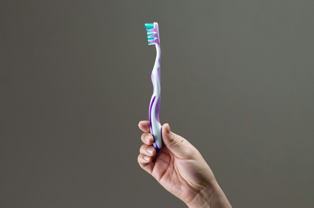 purple, green, and white toothbrush
