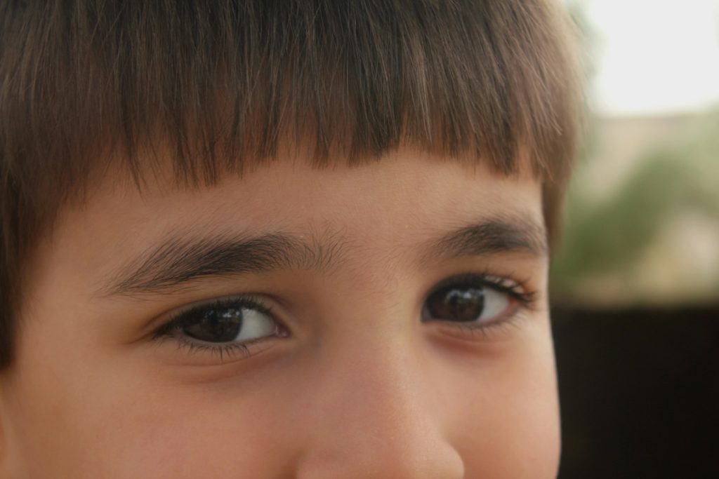 a close up of a young boy with a tooth brush in his mouth